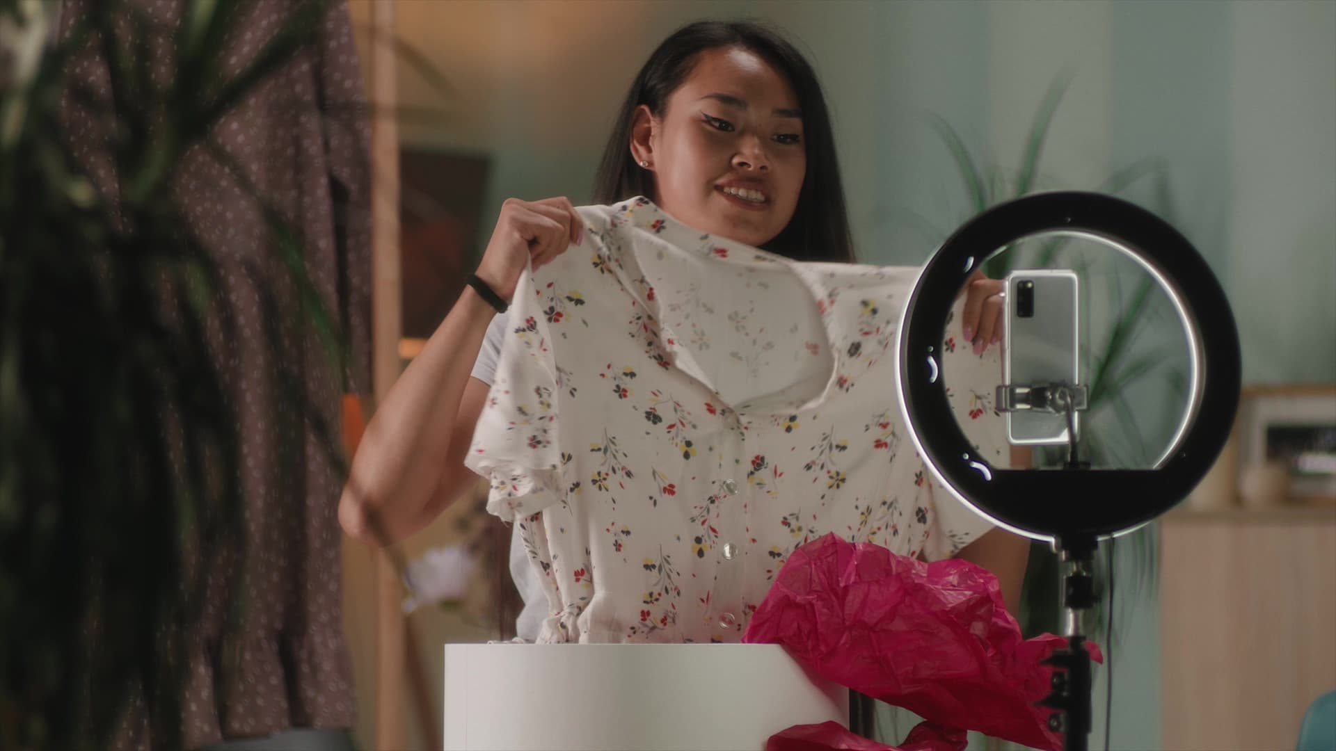 En tjej som filmar sig själv med mobilen när hon packar upp en nyinköpt tröja